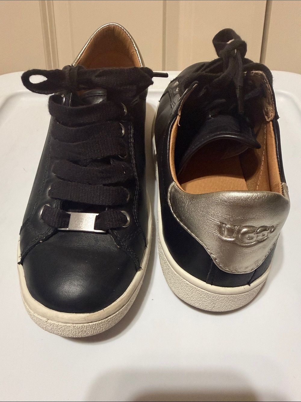 UGG women’s size 7 Black Leather Sneakers with Metallic Silver Heel Accent